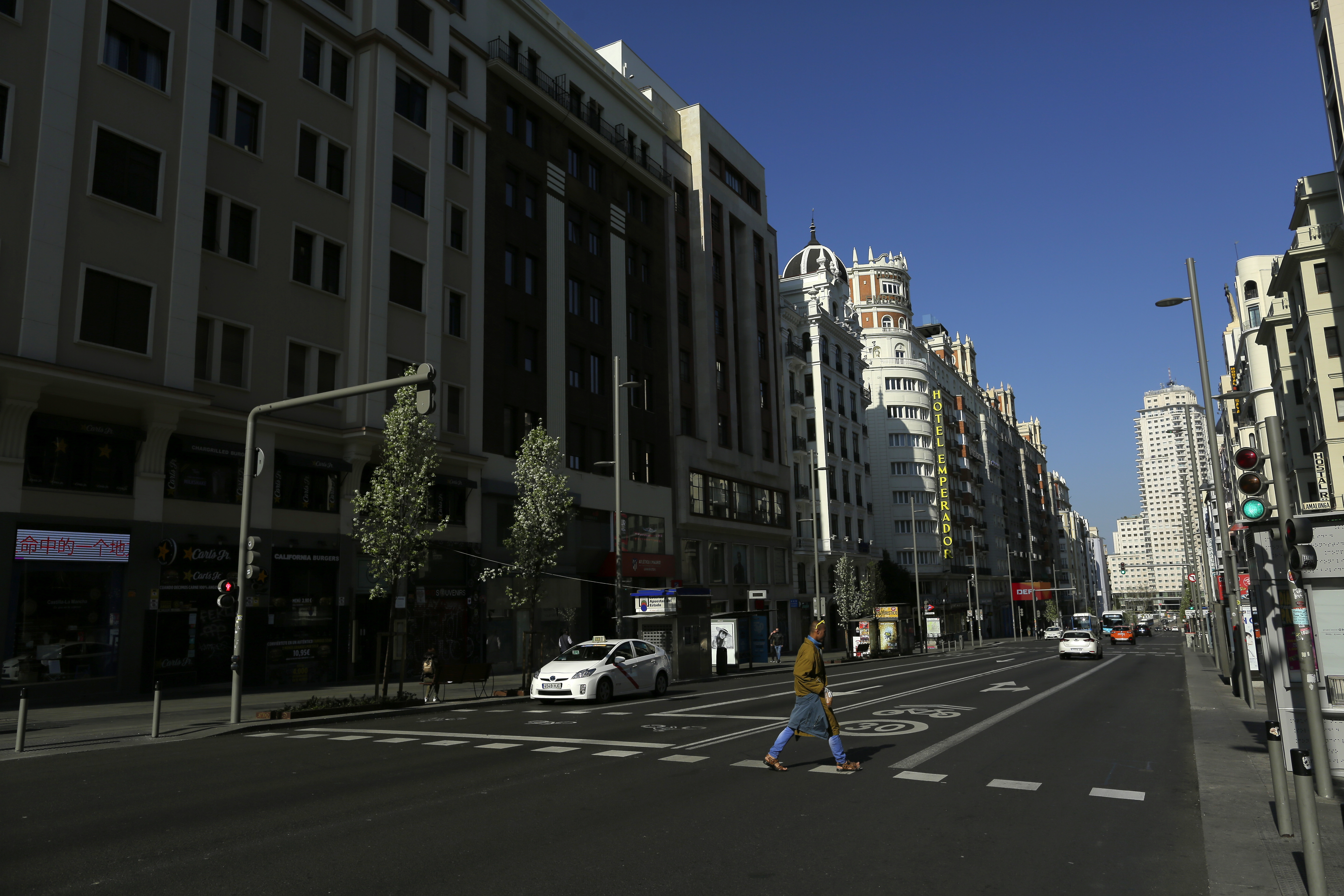 A man crosses a pedestrian crossing at the Gran Via avenue in downtown in Madrid, Spain, on Saturday.