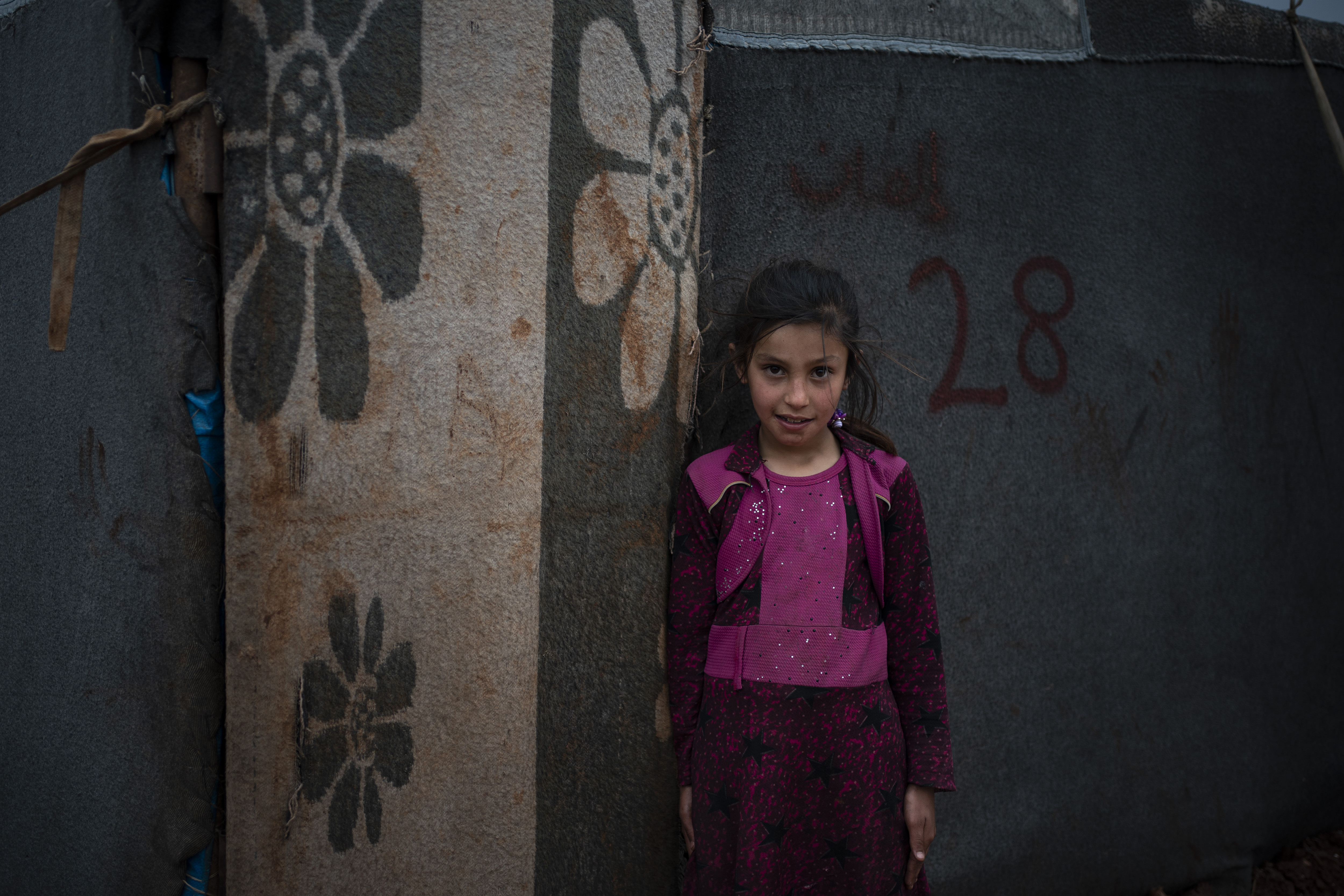 Yasmin poses for photo outside her tent at an informal camp for people displaced by fighting outside of Idlib city, Syria.