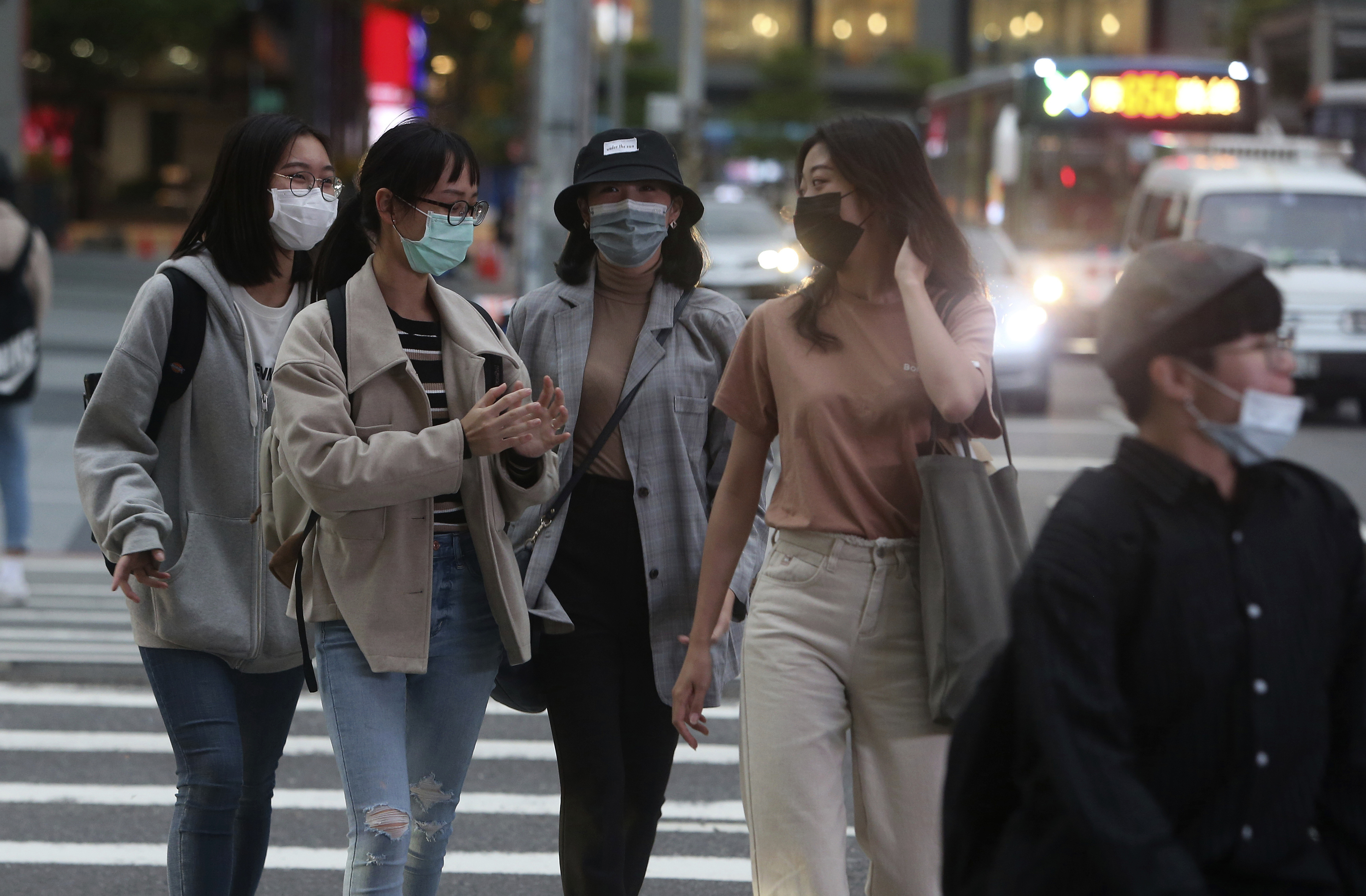 Pedestrians wear face masks to protect against the spread of the coronavirus
