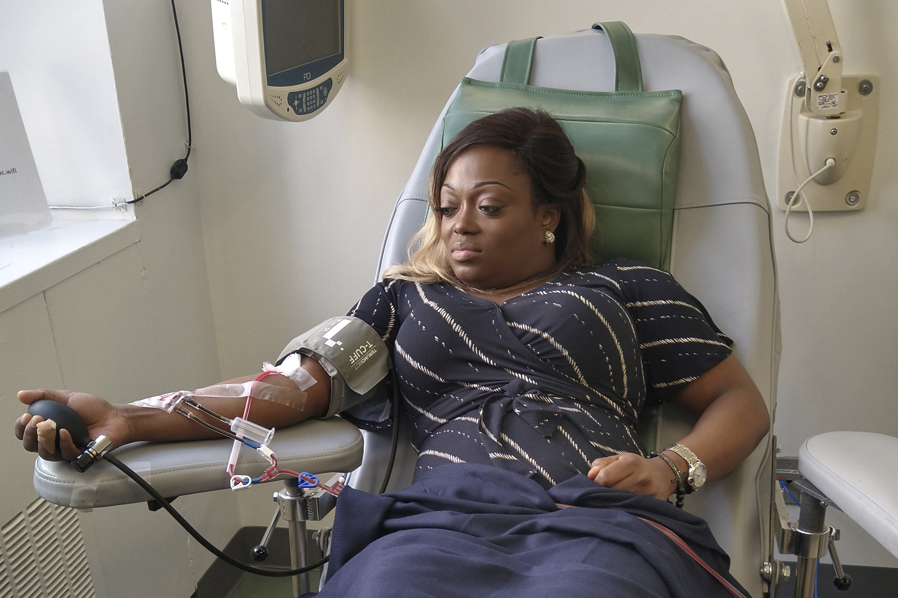 In this March 26, 2020 photo provided by Tiffany Pinckney, she donates blood for a study at a hospital in New York after recovering from COVID-19