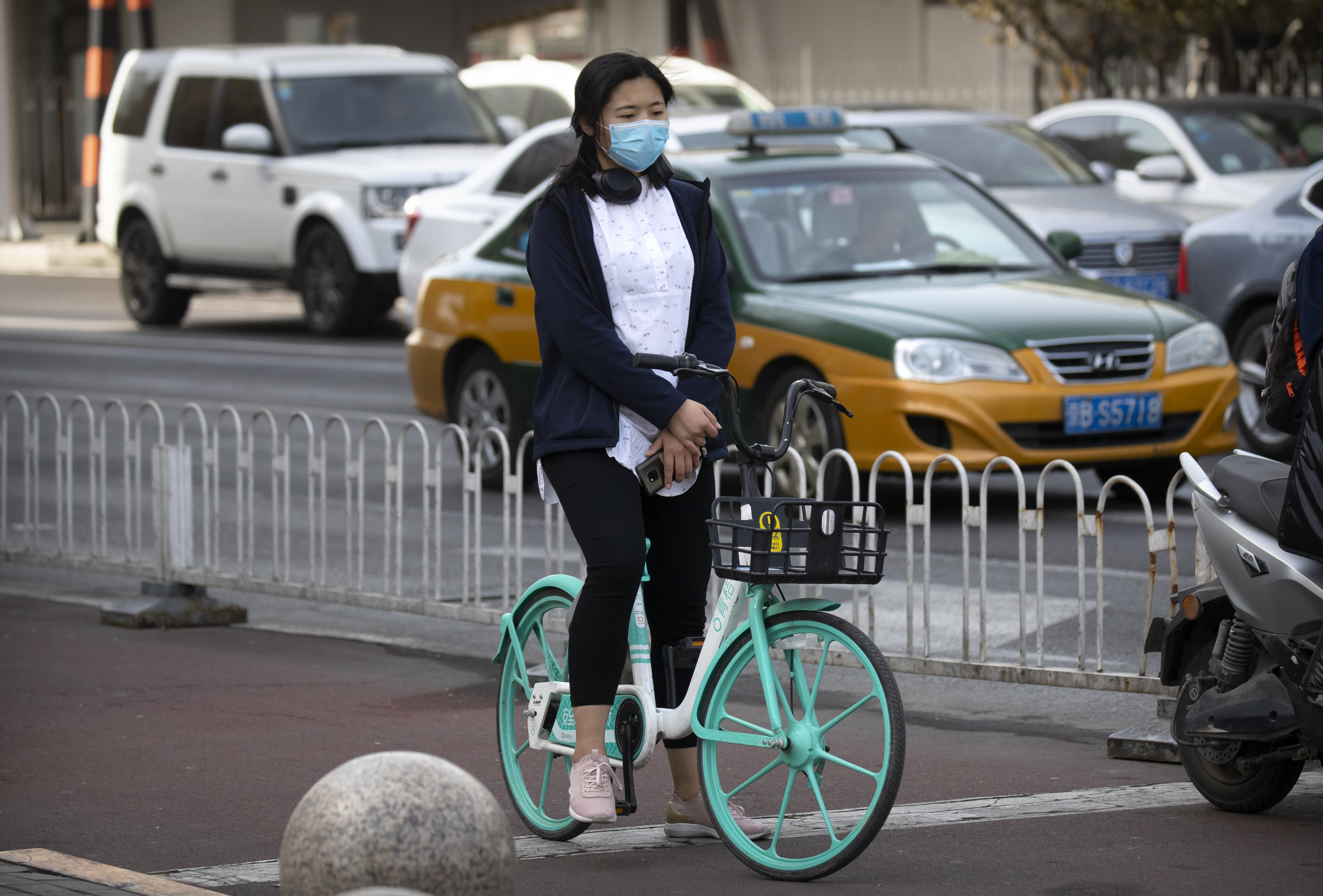 A cyclist pauses during a national moment of mourning for victims of the coronavirus, in Beijing