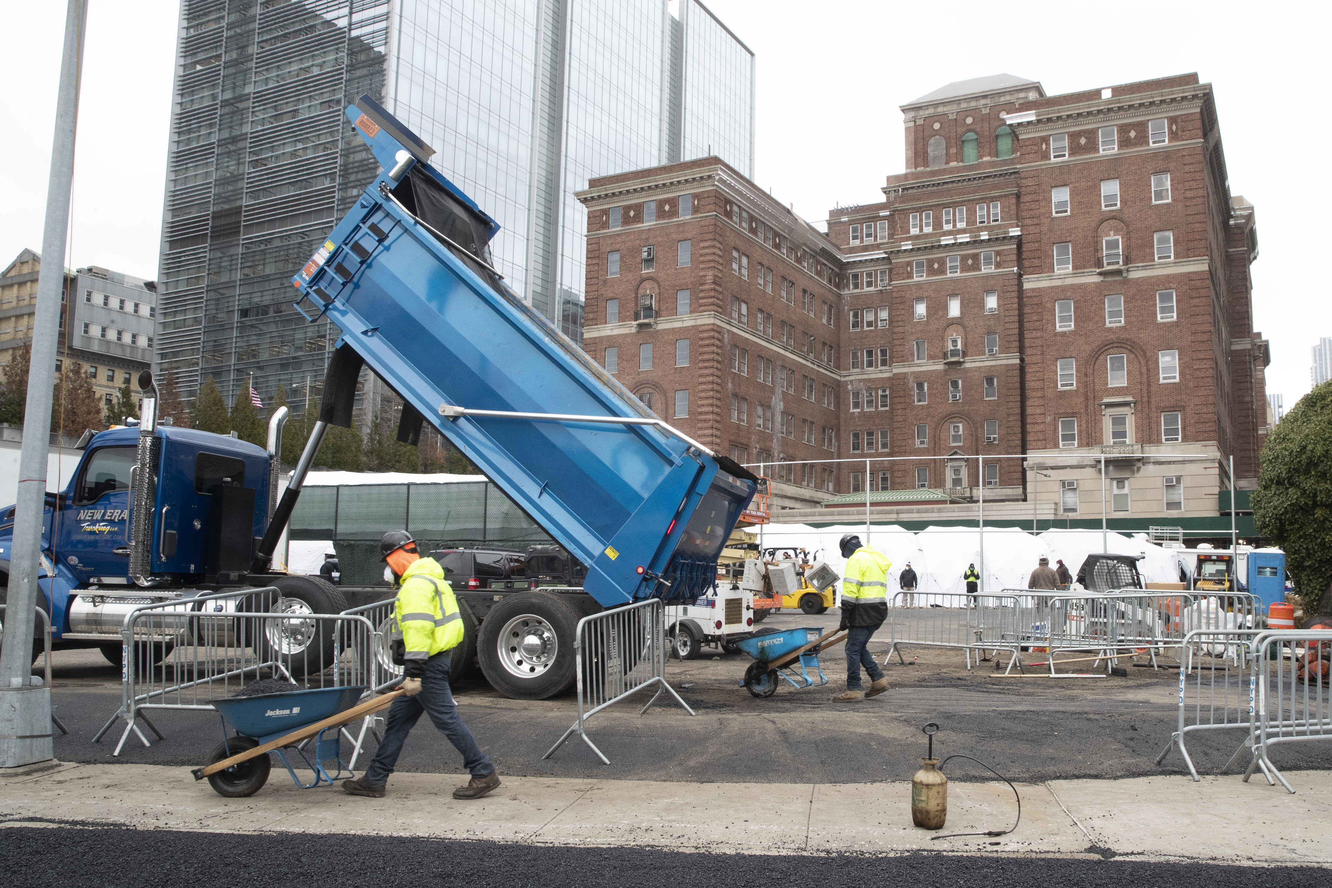 Construction workers are seen at the site of a makeshift morgue being built in New York