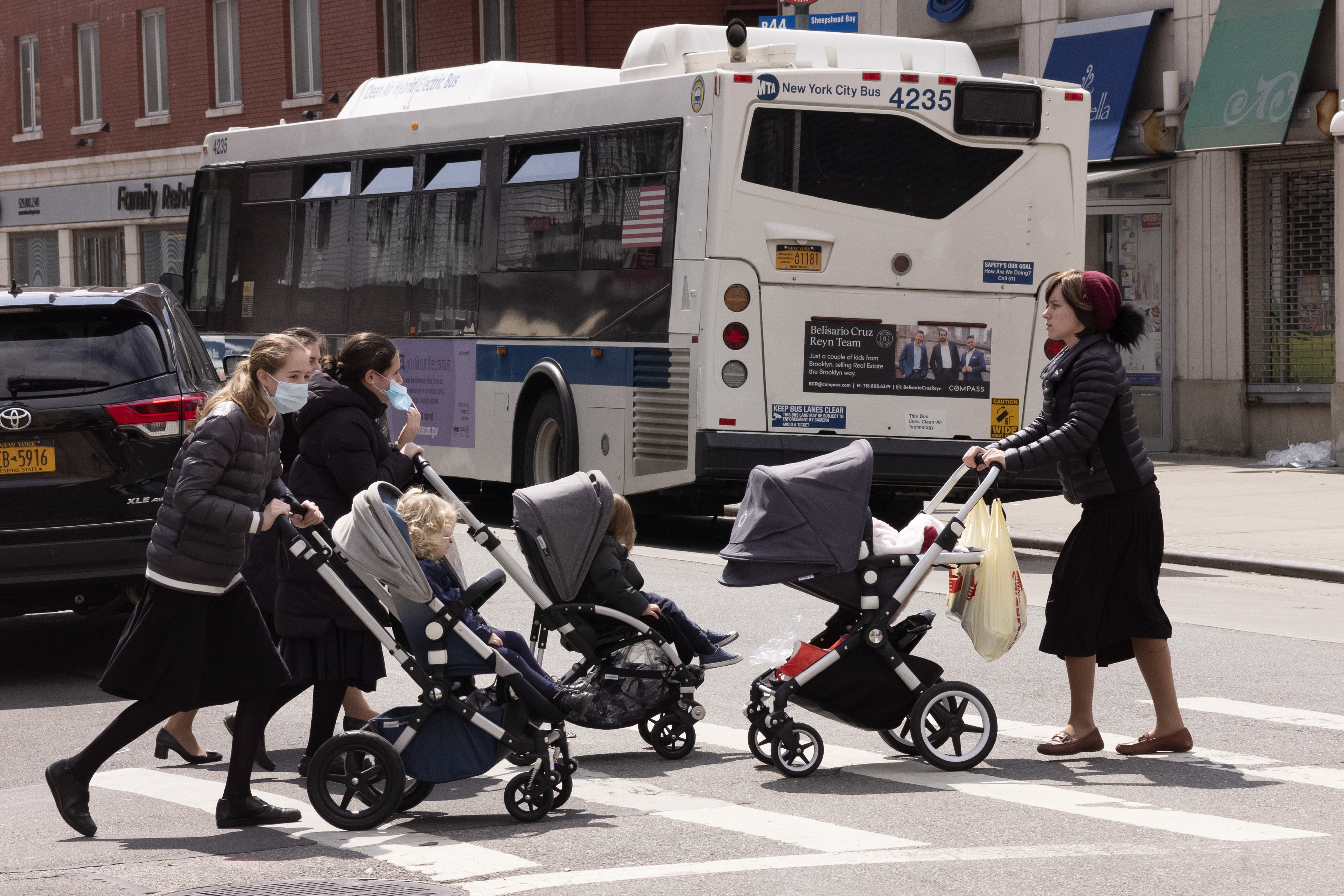 Women push strollers across a street on the first day of Passover