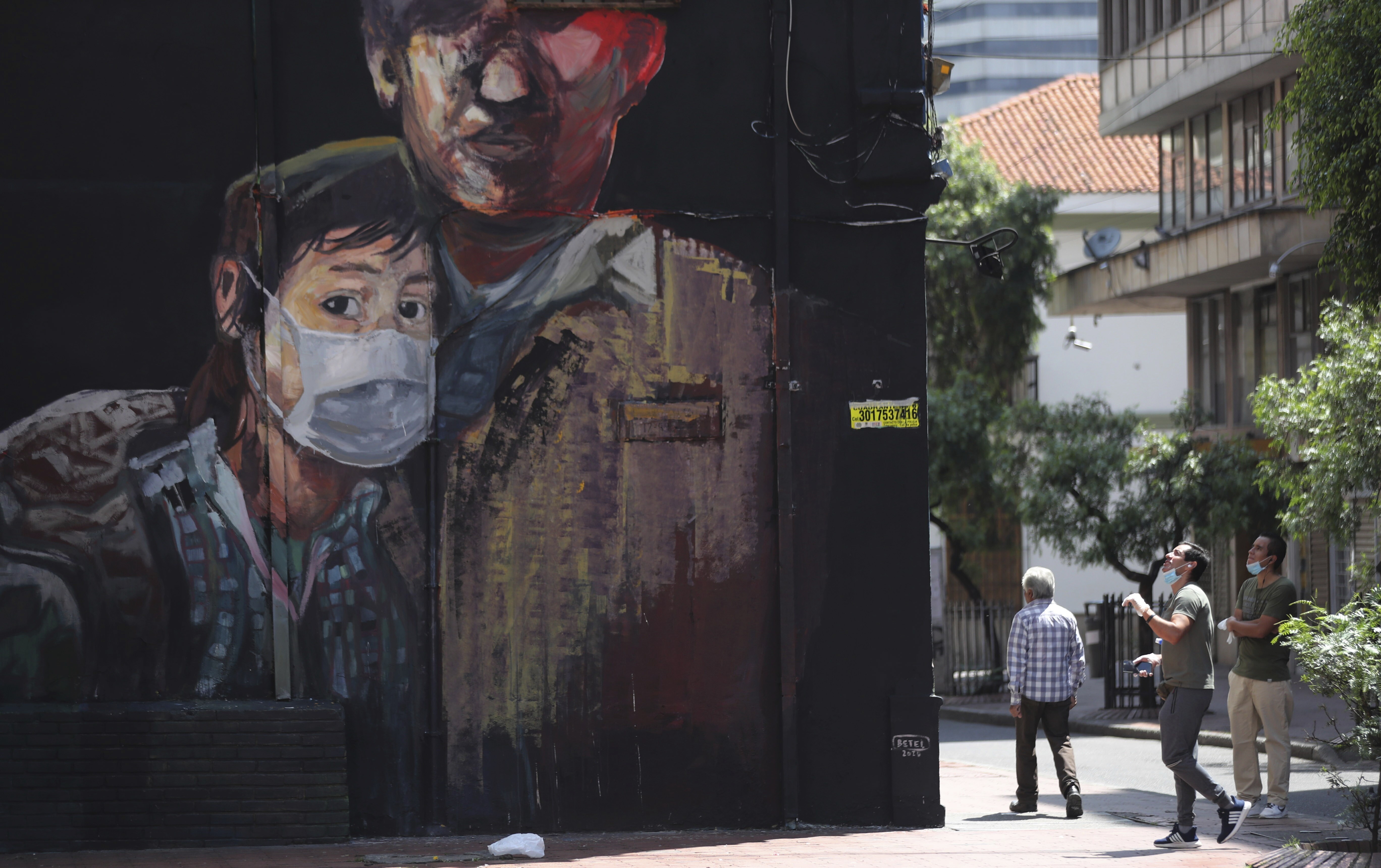 A newly painted mural shows a youth wearing a face mask, during a government ordered lockdown to prevent the spread of the new coronavirus in Bogota, Colombia