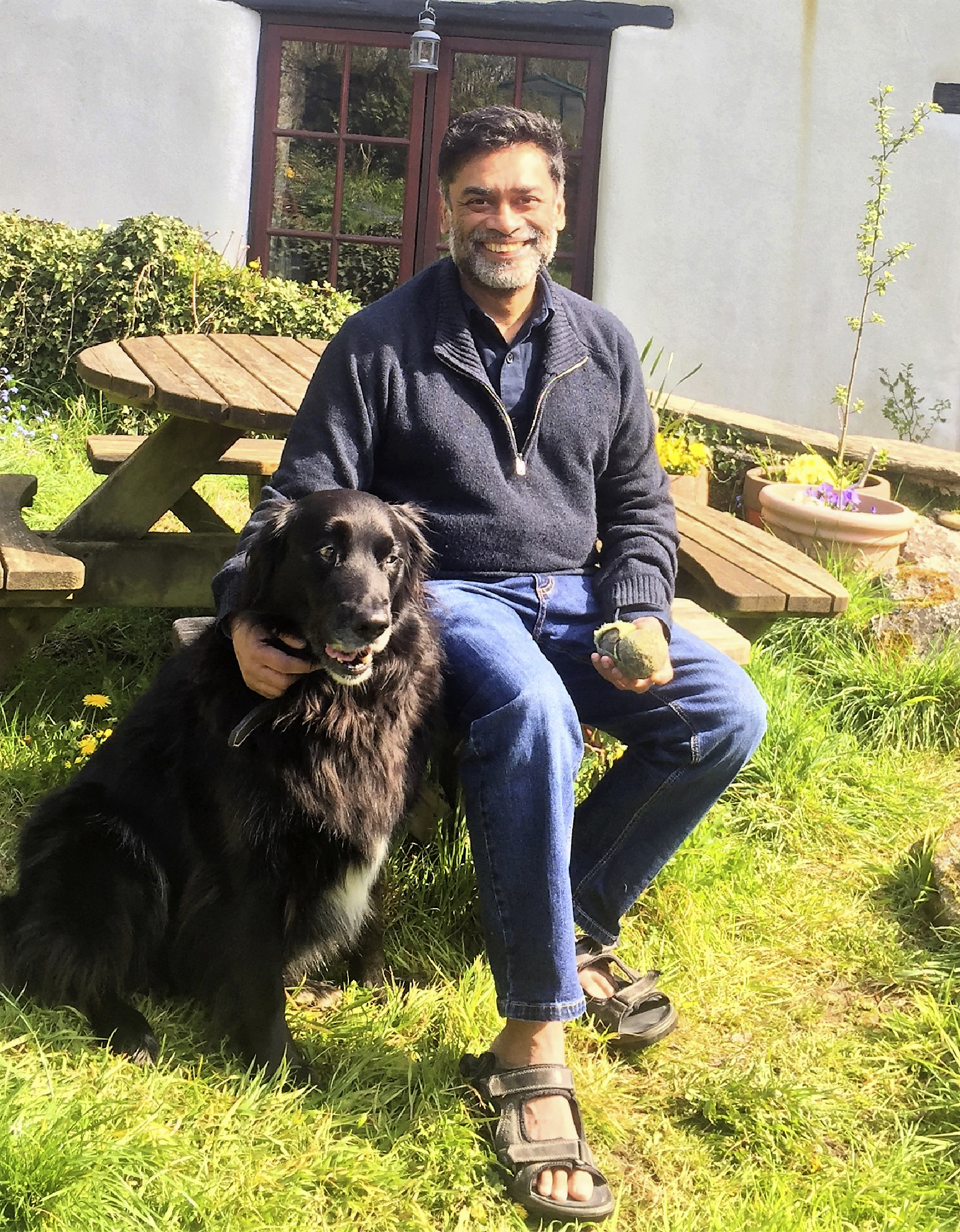 Dr. Poorna Gunasekera poses for a photo with his dog Barney at his home in the village of Filham, Devon, England, minutes after returning from hospital.