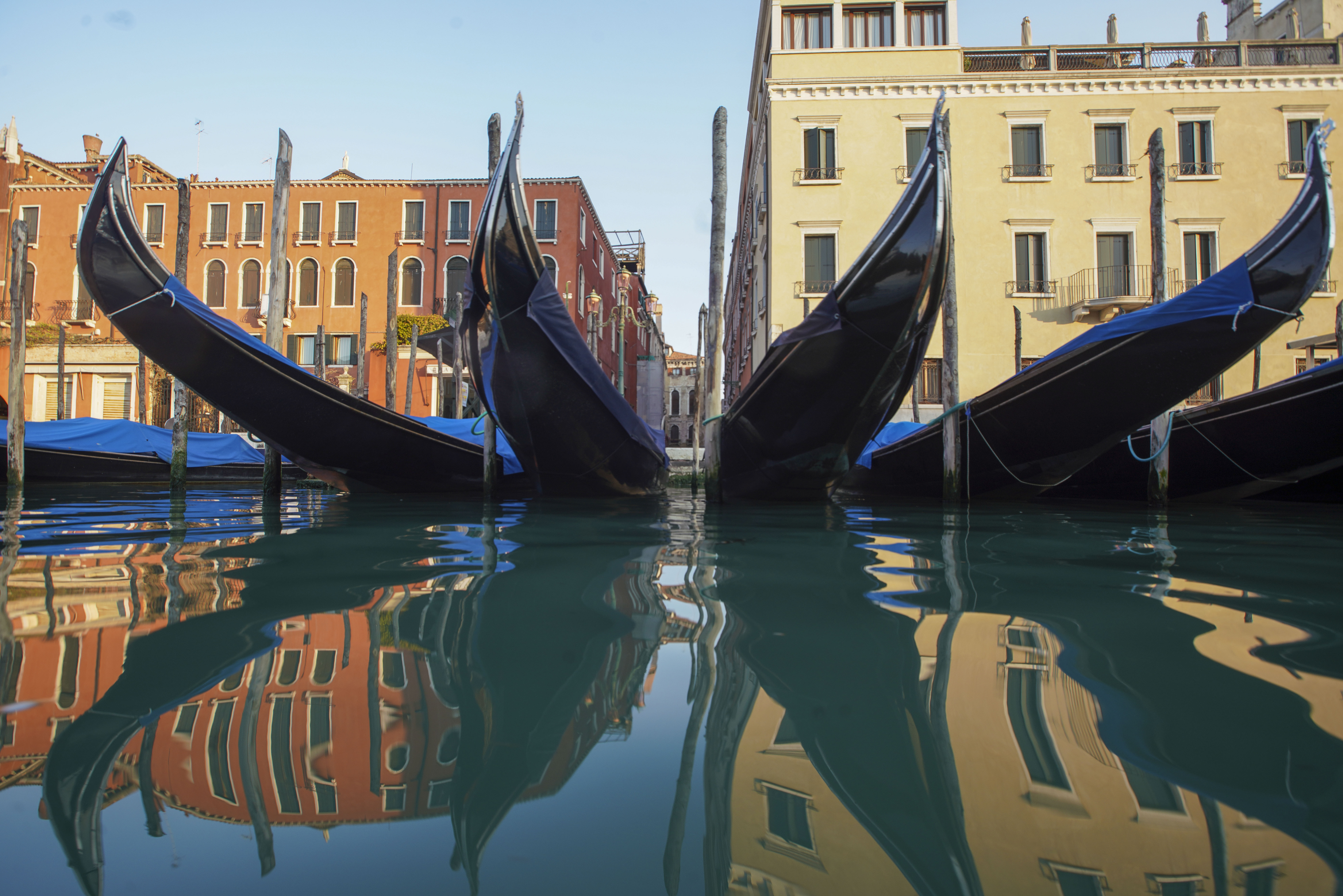 In this Monday, April 6, 2020 file photo, moored gondolas are reflected on the water of the Gran Canal, in Venice.