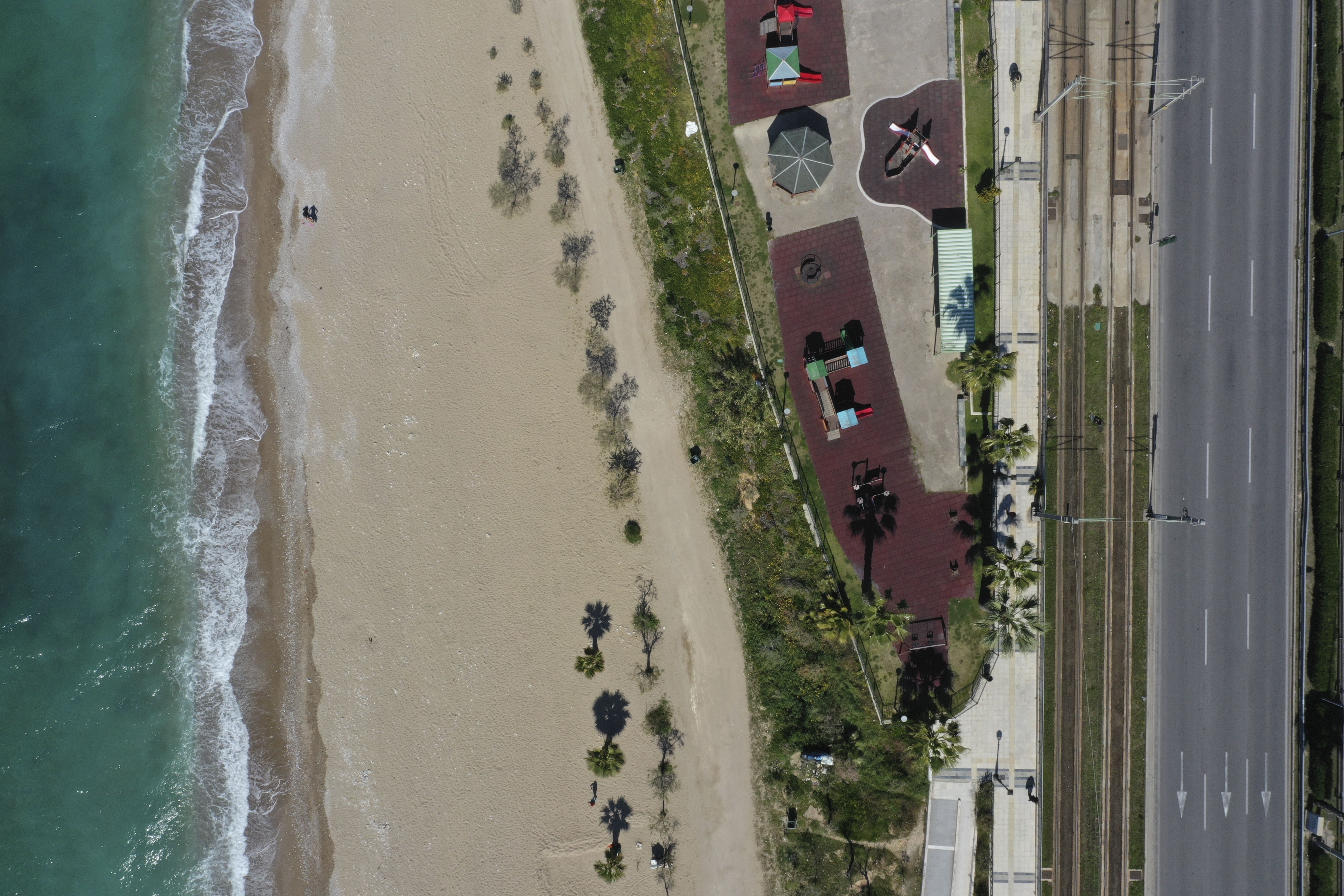 In this Thursday, April 2, 2020 aerial file photo, Poseidonos Avenue and the beach of Paleo Faliro in southern Athens during the lockdown to contain the spread of COVID-19.