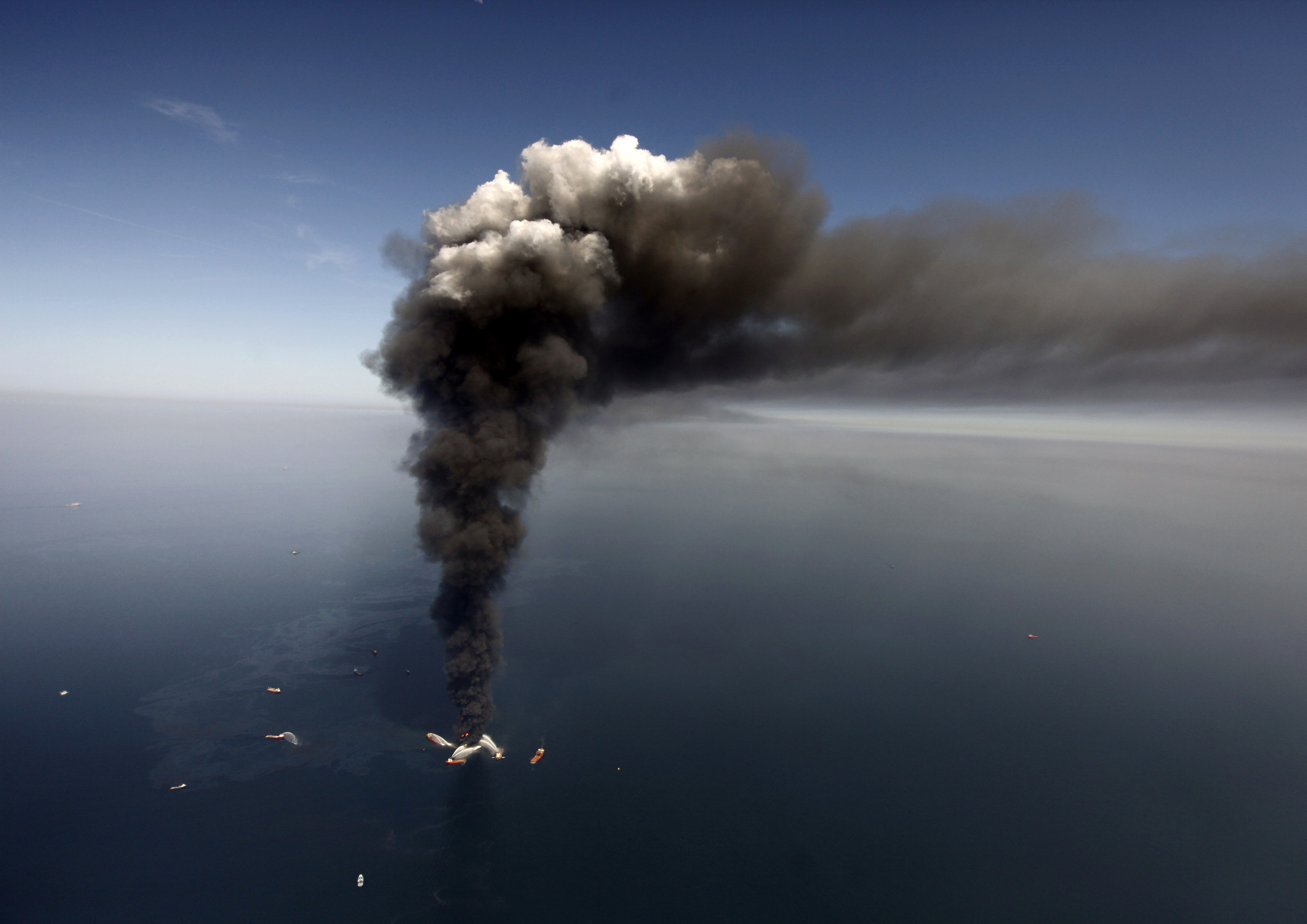 This April 21, 2010 file photo shows oil in the Gulf of Mexico, more than 50 miles southeast of Venice on Louisiana's tip, as the Deepwater Horizon oil rig burns.