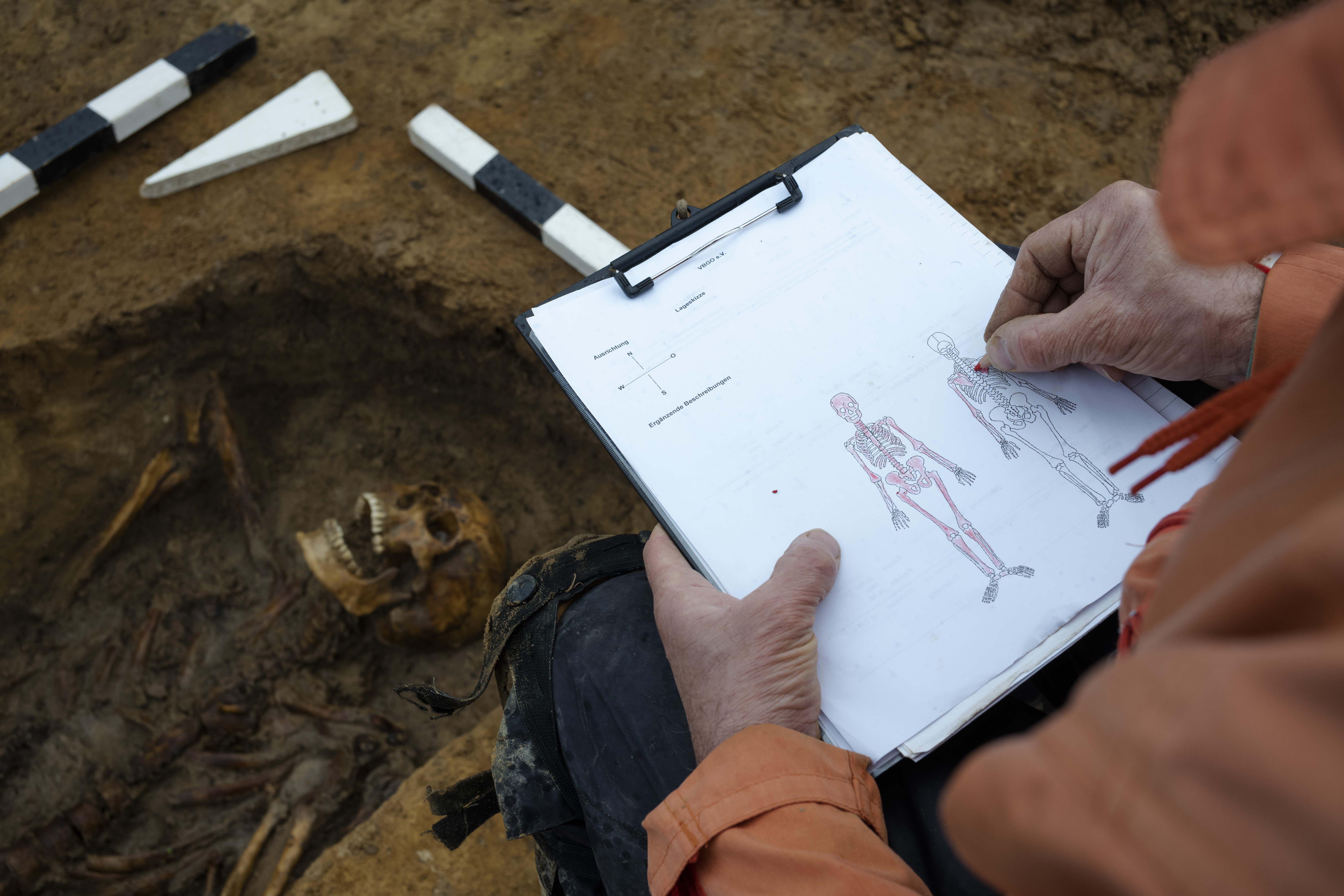 Werner Schulz an excavation technician makes a note of the bones of the remains of a Soviet soldier on a diagram to confirm they are the bones of one person, during a search for fallen WWII soldiers near the village of Klessin in Germany