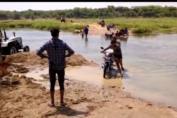 Villagers crossing river river in Datia eyes of administration