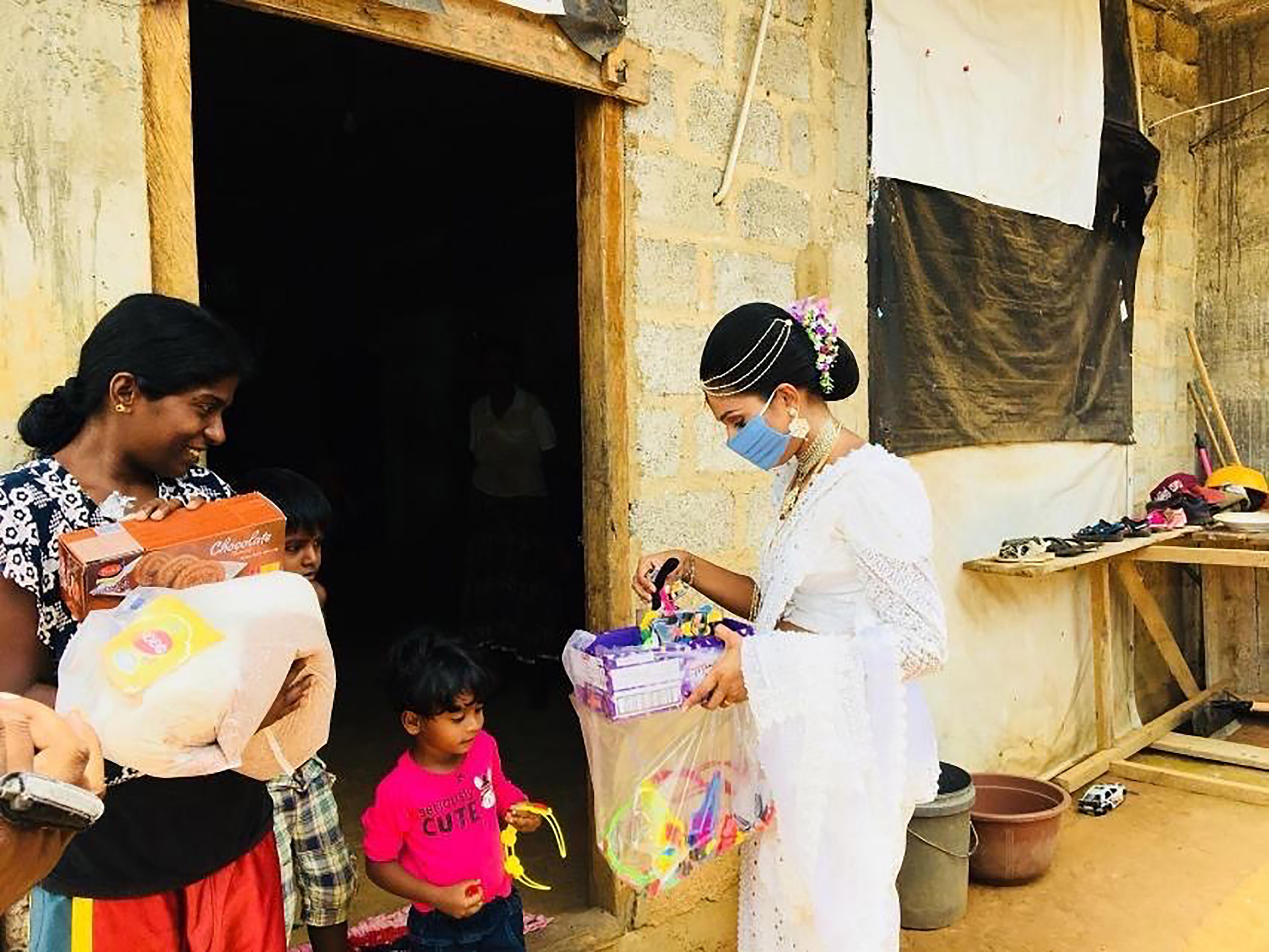 Pawani Rasanga hands a care package to a child in the small town of Malimbada, about 160 kilometers south of the capital Colombo.