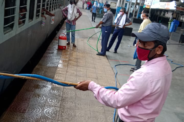 Scout guide's team serving water to passengers of shramik express in itarsi of hoshangabad