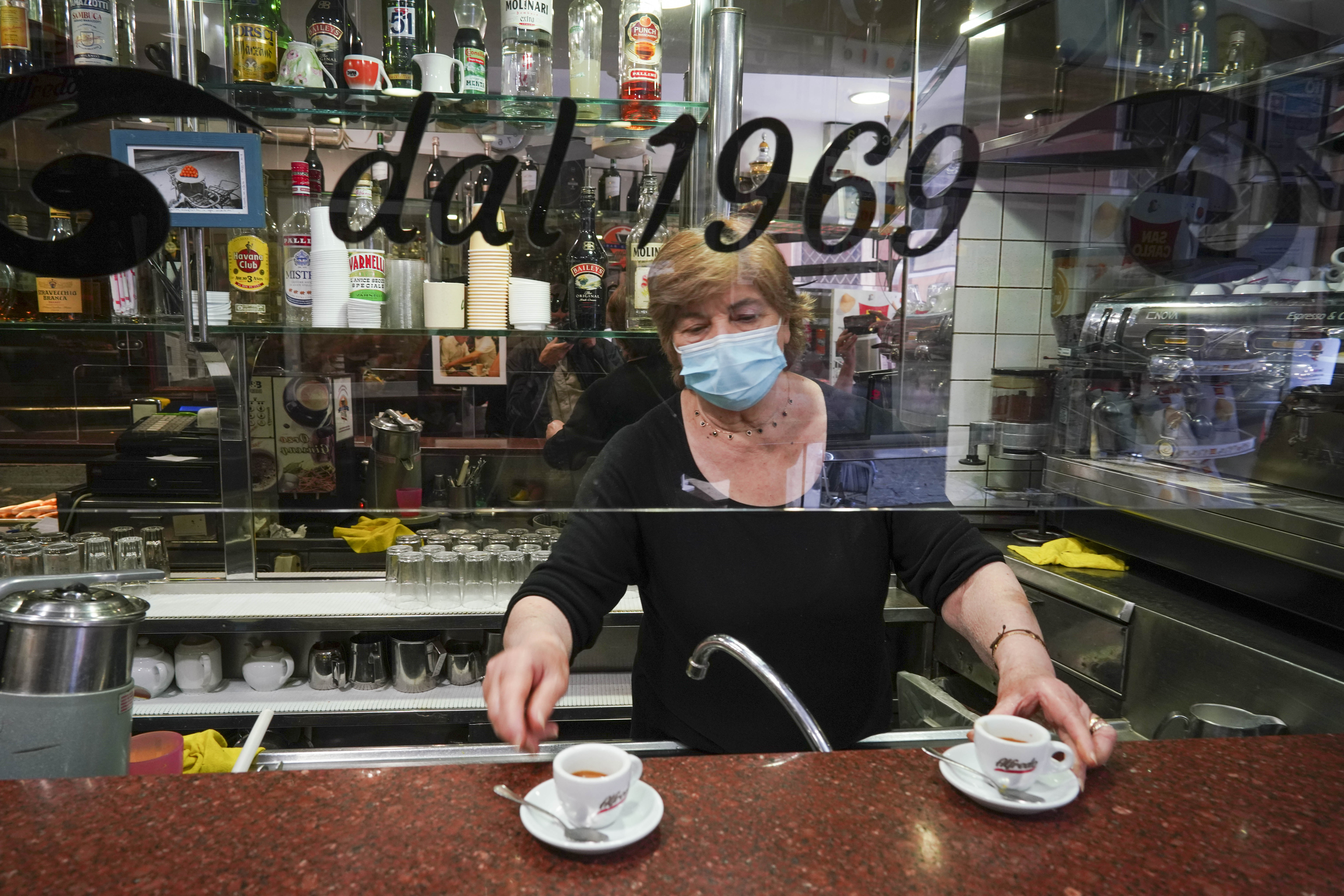 Coffee is served in the Caffe' Peru' bar, where a large plexiglass division was mounted over the counter to protect bartenders and customers from COVID-19 as they enjoy their drinks, in Rome.