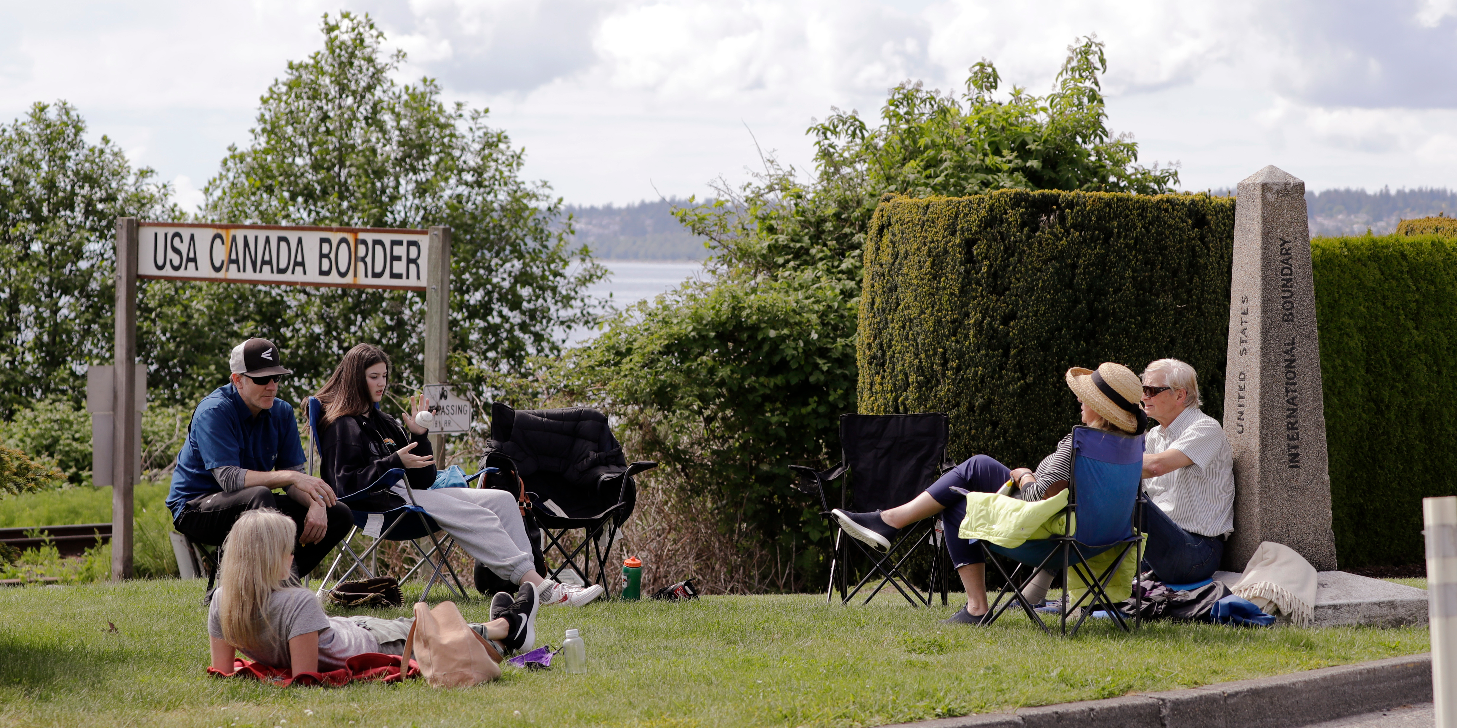 In this photo taken May 17, 2020, de Rham family members from the U.S. and Canada visit at the border between the countries in Peace Arch Park, in Blaine, Washington.