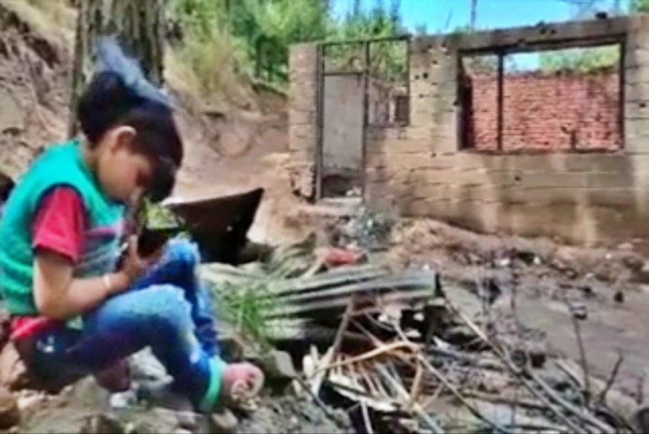 Seven-year-old Mehrun Nissa sits amid the ruins of her house