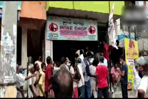 large crowd gathered outside liquor shop in visakhapatnam, social distancing norms flouted