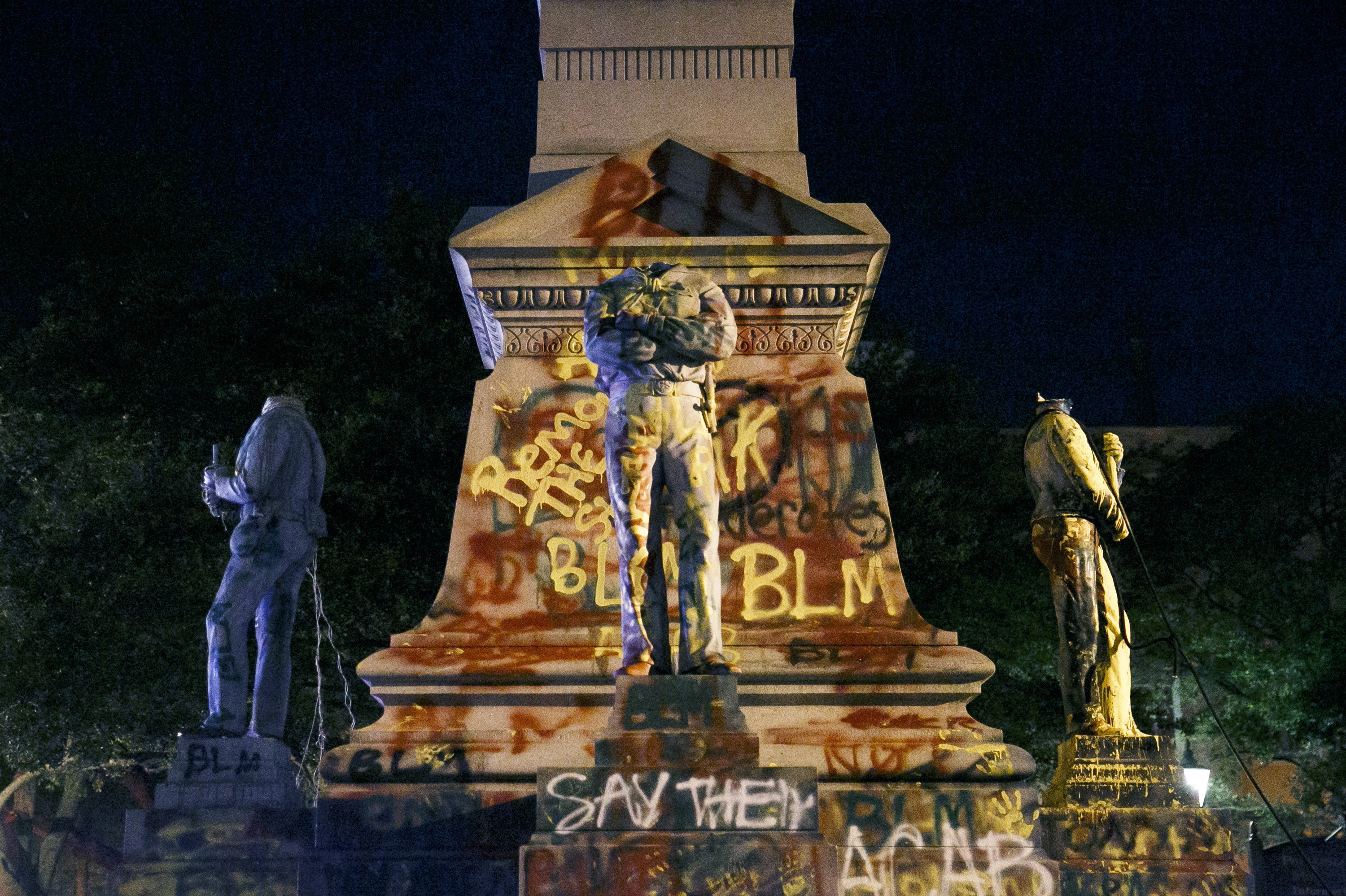 The statues on the Confederate monument are covered in graffiti and beheaded after a protest in Portsmouth,Virginia, on Wednesday.