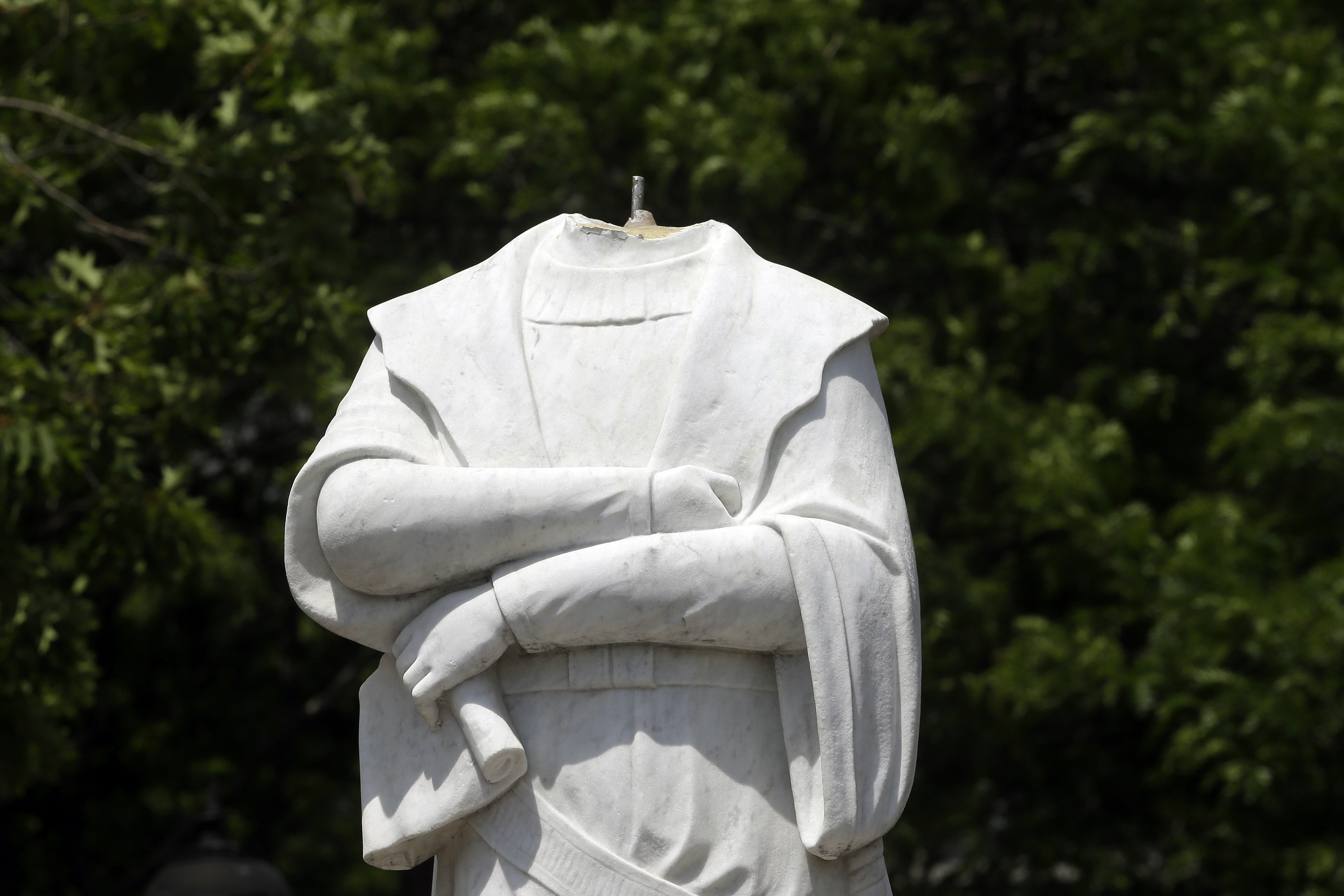 A damaged Christopher Columbus statue stands in a waterfront park near the city's traditionally Italian North End neighborhood, in Boston.