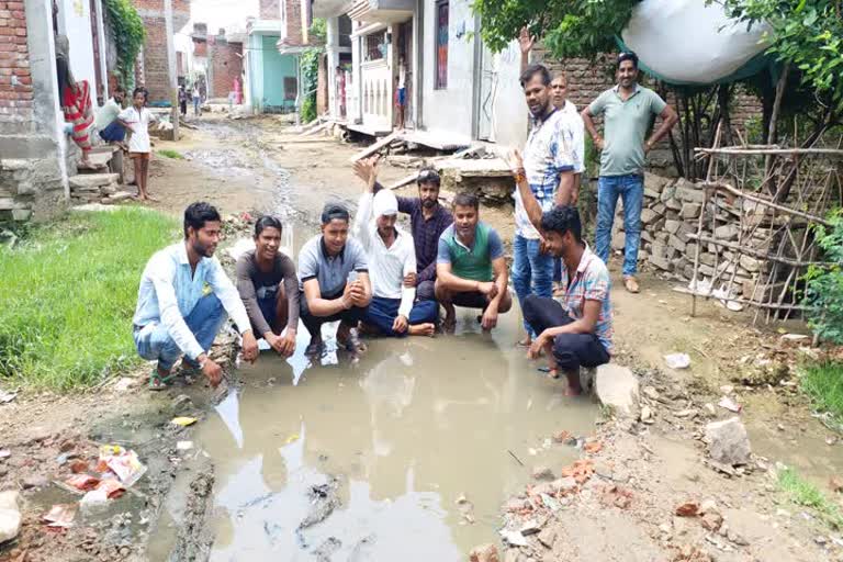 सड़क, पानी और बिजली की समस्या को लेकर कीचड़ में बैठकर किया विरोध प्रदर्शन