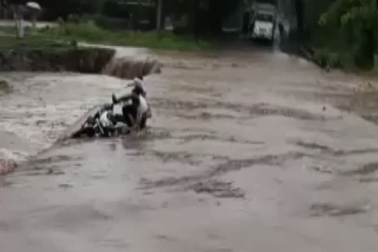 Two people washed away by the force of river while crossing the bridge on a bike