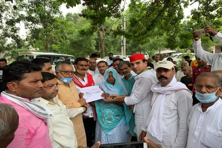 SP leader handing over check to deceased laborer's wife