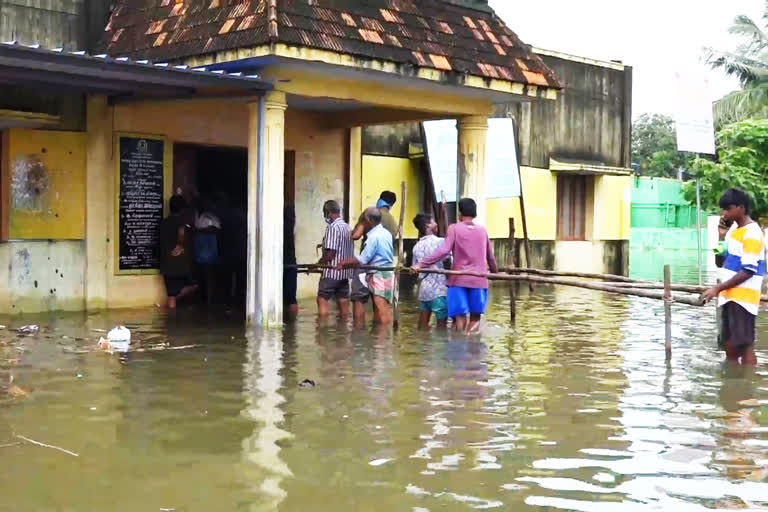 முழங்கால் அளவு தண்ணீரில் பொங்கல் பரிசு தொகுப்பு  வாங்கி செல்லும் அவலம்