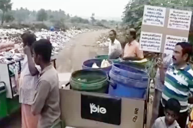 குப்பையை கொட்ட வந்த வாகனத்திடம் பொதுமக்கள் முறையிடுகின்றனர்