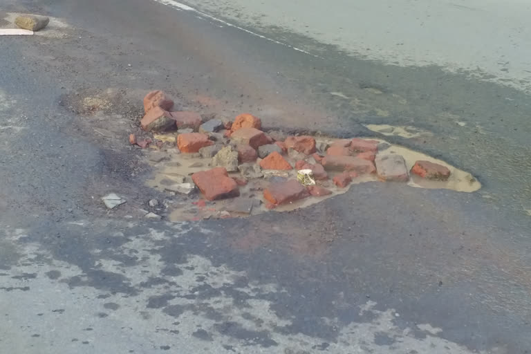 Leakage of water being stopped by putting brick pieces on Mall Road