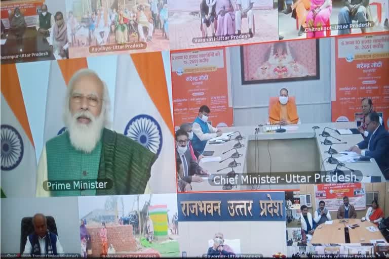 लाभार्थियों से बातचीत करते पीएम मोदी.