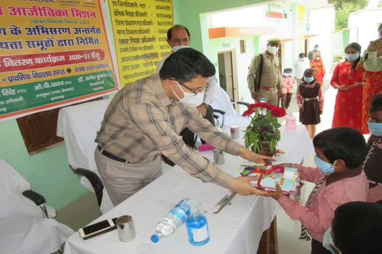 बच्चों को किताबें बांटते डीएम रूपेश कुमार.