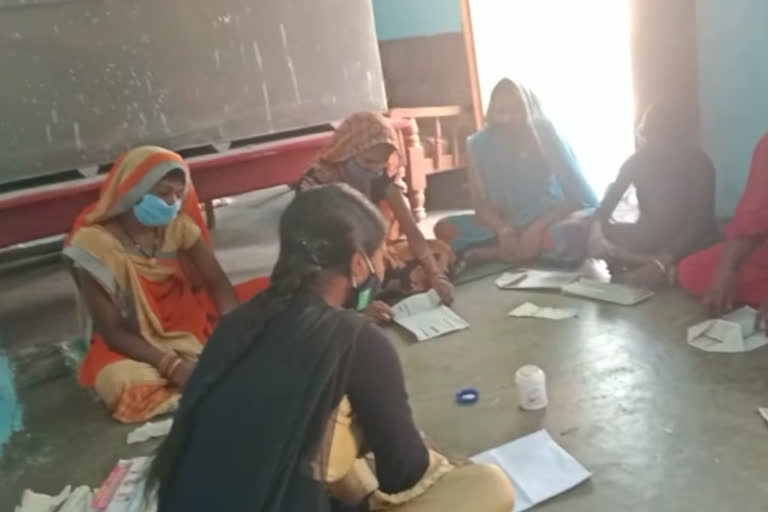 Women are preparing envelopes and paper bags