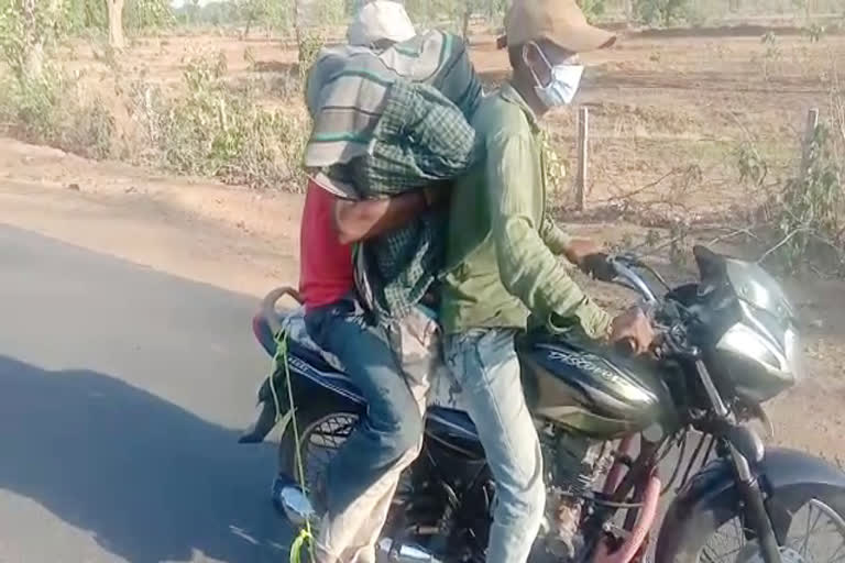 relatives carrying dead body tied with motorcycle