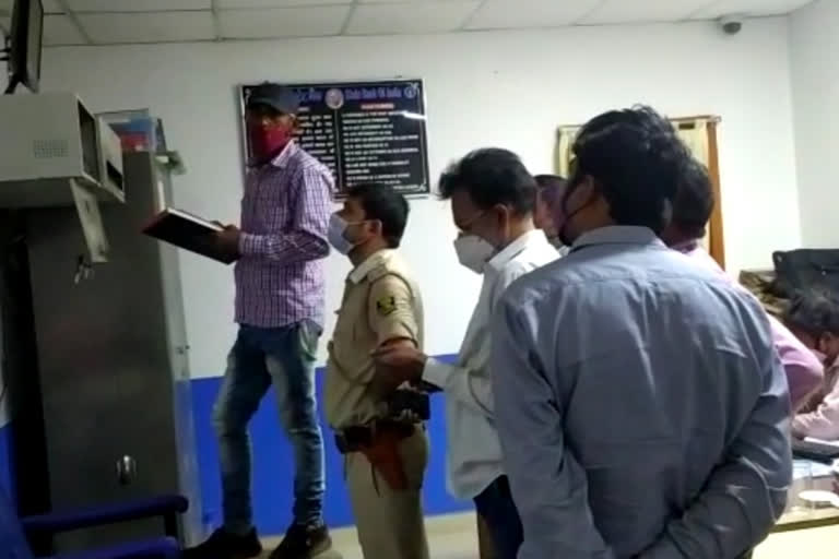 बैंक में जांच करती पुलिस