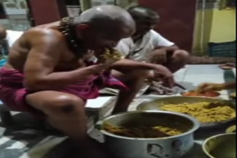 baba distributing prasad to devotees by spitting in mathura