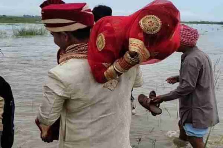 वर नववधुला खाद्यांवर उचलून नेत नदी पार