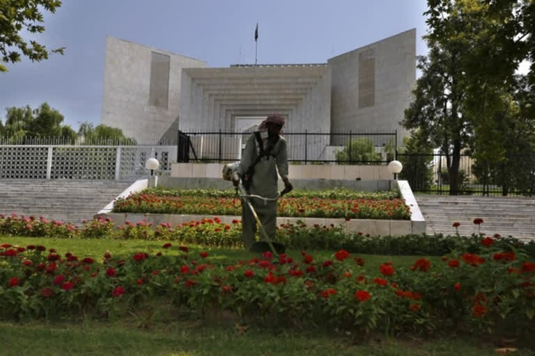 A worker mows the front lawn of the Supreme Court building