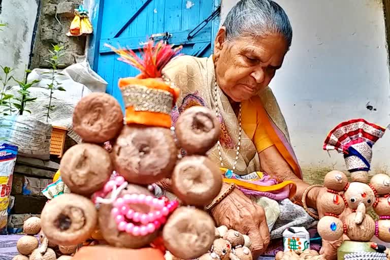 Elderly woman making idol of Lord Ganesha with betel nut