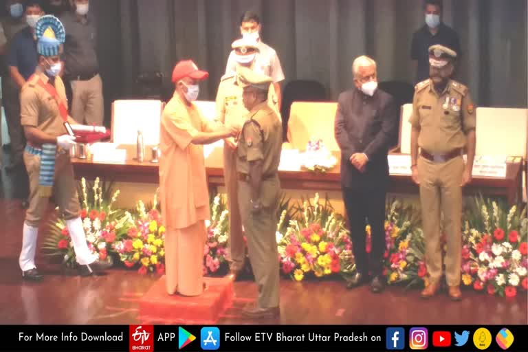 पुलिस कर्मियों को मेडल देकर सम्मानित करते सीएम योगी.