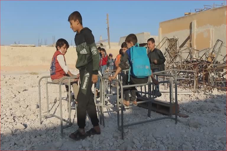 Syrian children attend classes at damaged school