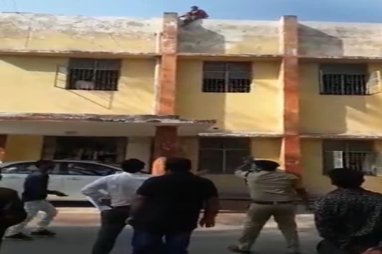 woman climbing on the roof of the court in korba