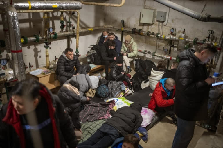 People take shelter at a building basement while the sirens sound announcing new attacks in the city of Kyiv, Ukraine