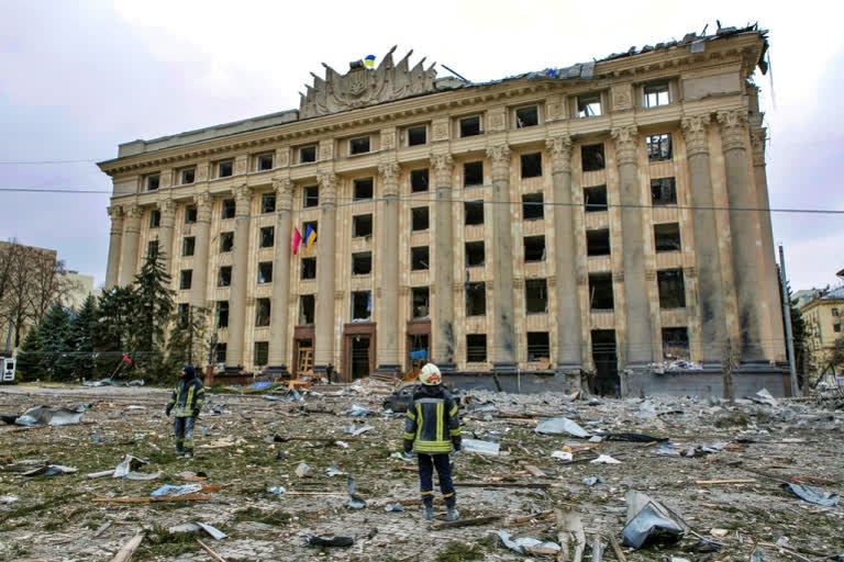 A member of the Ukrainian Emergency Service looks at the City Hall building in the central square following shelling in Kharkiv, Ukraine, Tuesday, March 1, 2022.