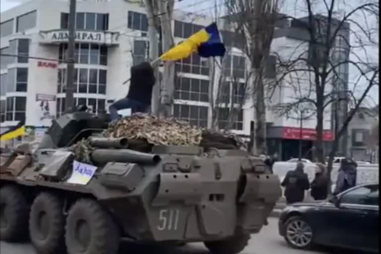 Ukrainian man climbs onto Russian tank