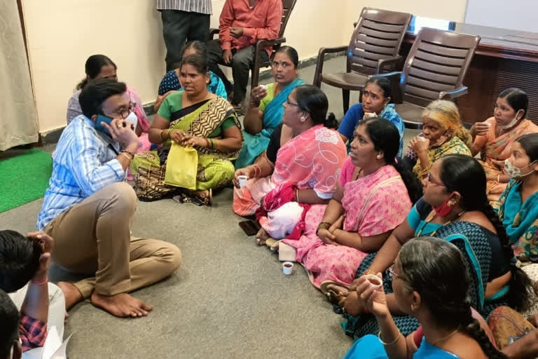 Commissioner sitting on the floor listening to the victims' problems