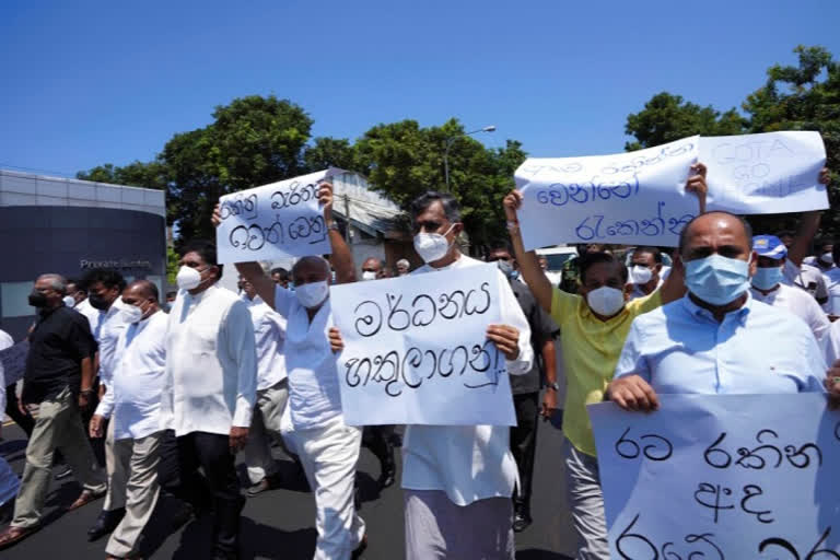 Opposition lawmakers in Sri Lanka on Sunday marched in the capital, Colombo, defying the president's move to impose a nationwide curfew and state of emergency after protests blaming the government for an economic crisis swelled