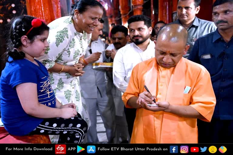 Varanasi  Varanasi latest news  etv bharat up news  CM योगी आदित्यनाथ  बच्ची को दिया ऑटोग्राफ  CM Yogi Adityanath  Yogi Adityanath gave autograph  मुख्यमंत्री योगी आदित्यनाथ  श्री काशी विश्वनाथ धाम