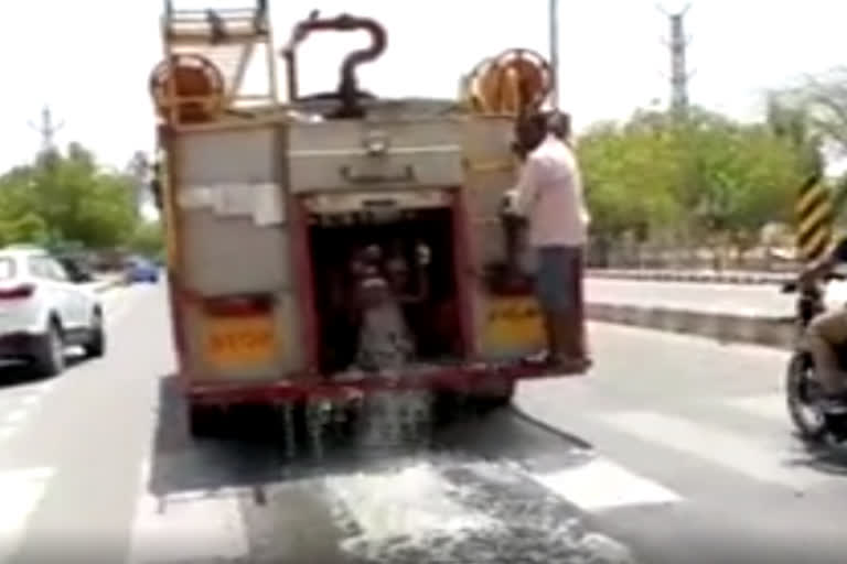 Fire bridge sprinkling water on road in Churu