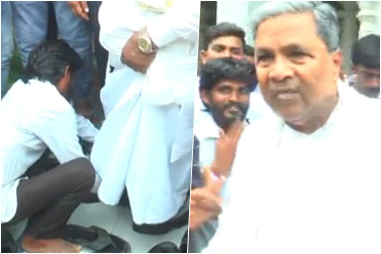 man help to Siddaramaiah wear the shoes