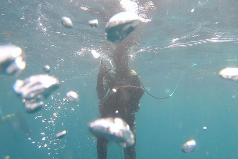 fish jumps into mans mouth