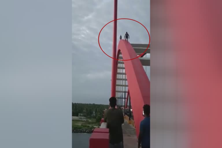 youngsters dangerously walking through the arch of valiyazheekkal bridge  youngsters dangerously walking through valiyazheekkal bridge arch  valiyazheekkal bridge arch youngsters stunt  വലിയഴീക്കൽ പാലം യുവാക്കളുടെ അഭ്യാസപ്രകടനം  വലിയഴീക്കൽ പാലത്തിന്‍റെ ആർച്ചിലൂടെ നടന്നു കയറി  വലിയഴീക്കൽ പാലം പുതിയ വാർത്ത  ആലപ്പുഴ വാർത്ത  വലിയഴീക്കൽ പാലത്തിൽ യുവാക്കളുടെ അഭ്യാസപ്രകടനം